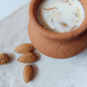 Hyderabadi milk sharbat served in a traditional clay pot with almonds.
